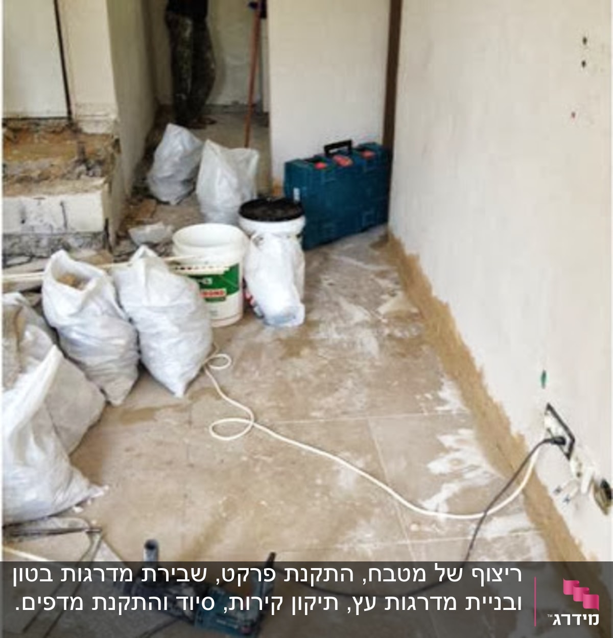 שקיות חומרי בניין, דלי צבע, כלי עבודה על רצפה